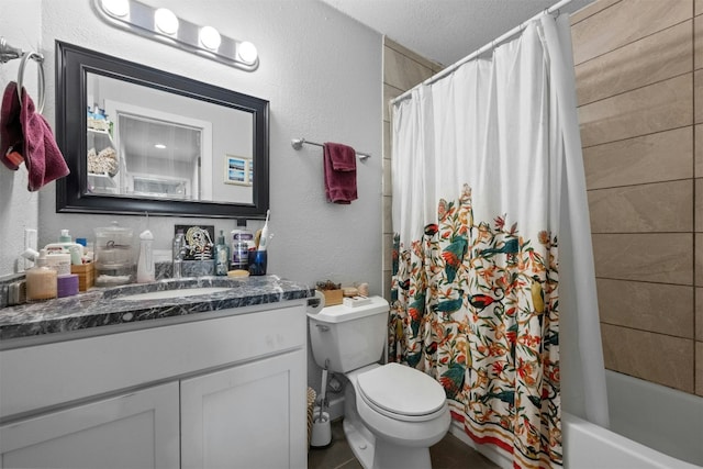 bathroom featuring a textured wall, toilet, shower / bath combo with shower curtain, a textured ceiling, and vanity