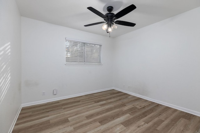 empty room with a ceiling fan, baseboards, and wood finished floors