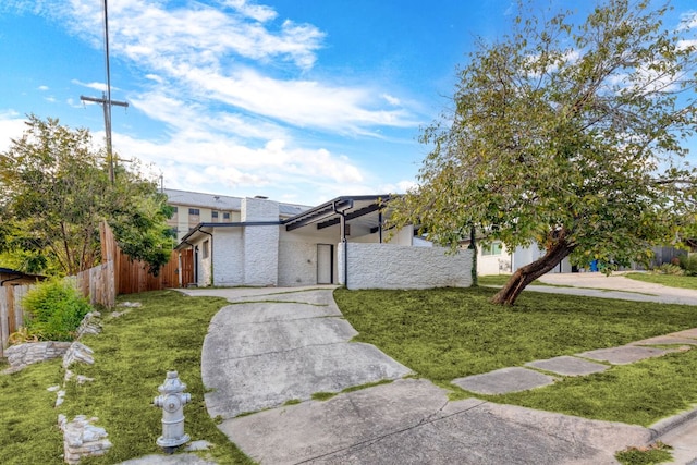 view of front facade featuring fence and a front lawn