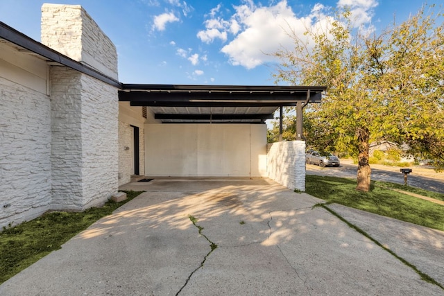 view of car parking with concrete driveway and a carport