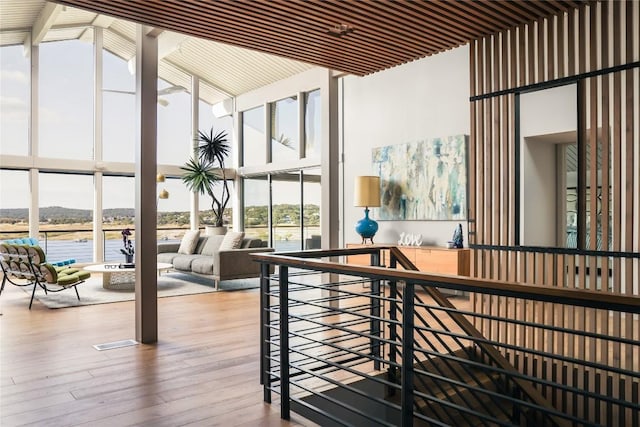 719 Cutlass St, Austin, TX 78734 - corridor featuring expansive windows, high vaulted ceiling, wood finished floors, beam ceiling, and a water view