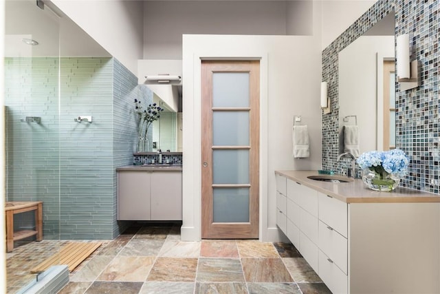 719 Cutlass St, Austin, TX 78734 - full bathroom featuring tasteful backsplash, two vanities, tiled shower, stone finish flooring, and tile walls