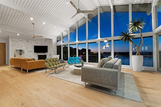 719 Cutlass St, Austin, TX 78734 - living area featuring a ceiling fan, wood finished floors, beamed ceiling, high vaulted ceiling, and a stone fireplace