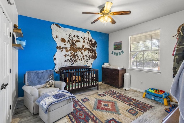 bedroom with ceiling fan, baseboards, and wood finished floors