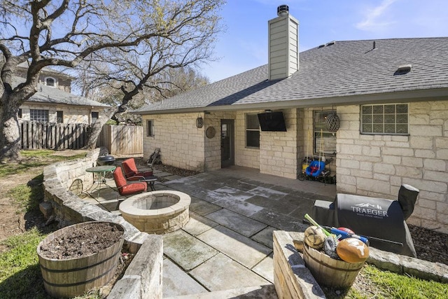 view of patio with fence and a fire pit