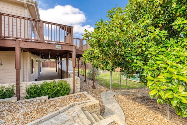 view of patio featuring fence and a wooden deck