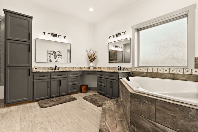 bathroom with a garden tub and vanity