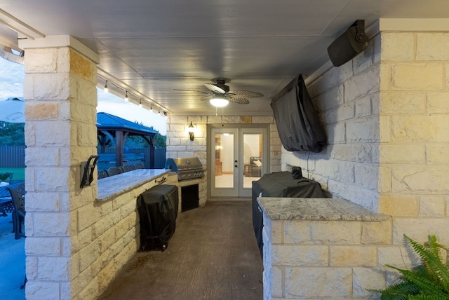 view of patio / terrace featuring a ceiling fan, an outdoor kitchen, area for grilling, and french doors