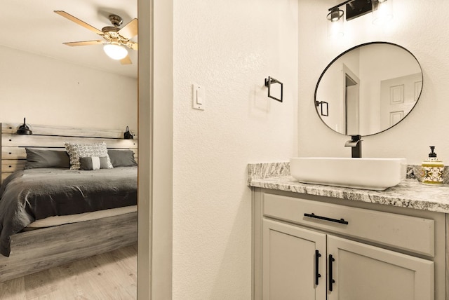 ensuite bathroom with vanity, a ceiling fan, wood finished floors, and ensuite bathroom