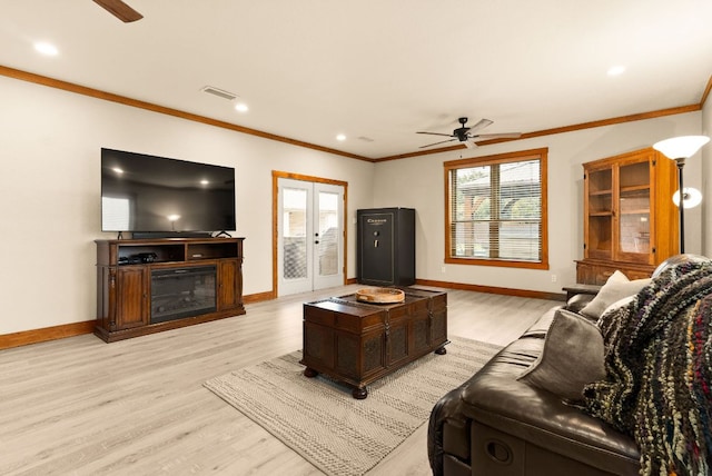 living area featuring light wood finished floors, plenty of natural light, visible vents, and ornamental molding