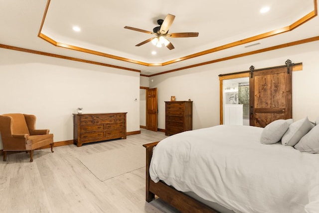 bedroom with a barn door, baseboards, a raised ceiling, and ornamental molding