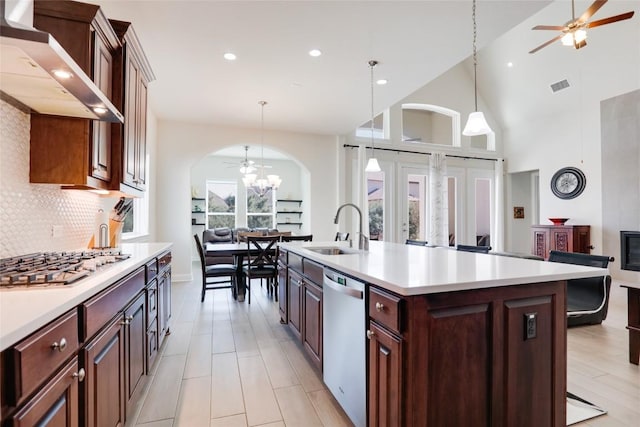 4104 Belisario Ct, Leander, TX 78641 - kitchen with stainless steel appliances, wall chimney exhaust hood, ceiling fan, arched walkways, and recessed lighting
