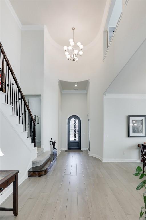 4104 Belisario Ct, Leander, TX 78641 - entrance foyer with a high ceiling, a chandelier, crown molding, and stairway