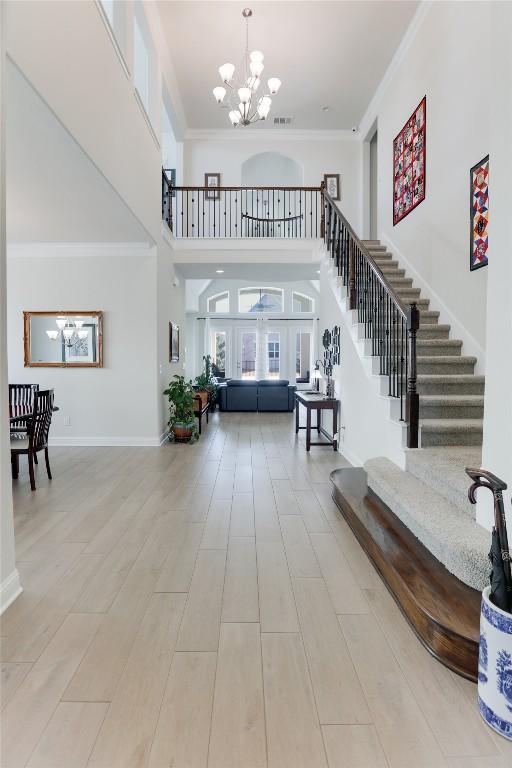 4104 Belisario Ct, Leander, TX 78641 - entryway featuring a chandelier, stairway, a high ceiling, crown molding, and french doors