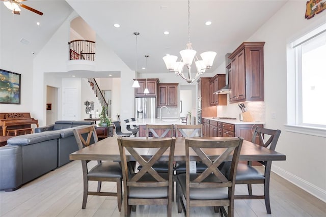 4104 Belisario Ct, Leander, TX 78641 - dining room featuring light wood-style flooring, a chandelier, a ceiling fan, recessed lighting, and stairs