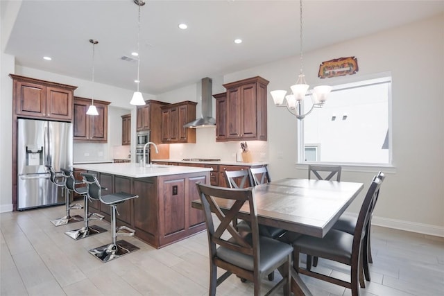 4104 Belisario Ct, Leander, TX 78641 - kitchen with appliances with stainless steel finishes, wall chimney range hood, tasteful backsplash, light countertops, and recessed lighting