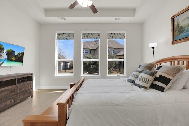 4104 Belisario Ct, Leander, TX 78641 - bedroom with a raised ceiling, light wood-style flooring, and a ceiling fan