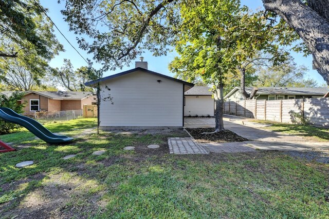 1520 Weyford Dr, Austin, TX 78757 - back of house with a fenced backyard, a chimney, and a playground
