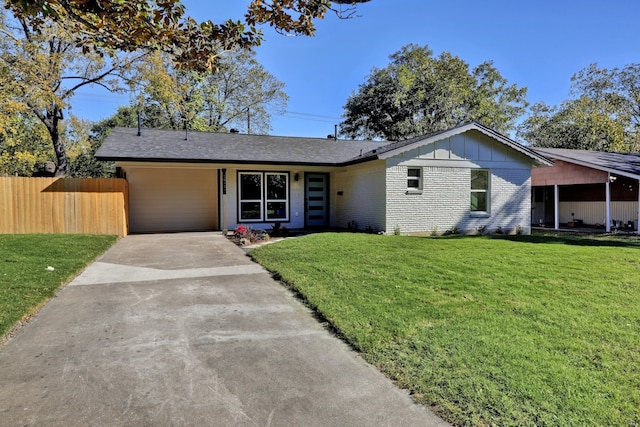 view of front facade featuring brick siding, concrete driveway, board and batten siding, fence, and a front lawn