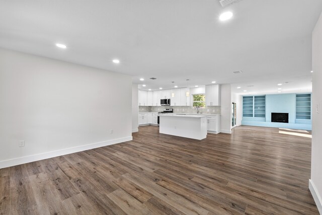 1520 Weyford Dr, Austin, TX 78757 - unfurnished living room featuring recessed lighting, dark wood-style floors, and a fireplace with raised hearth
