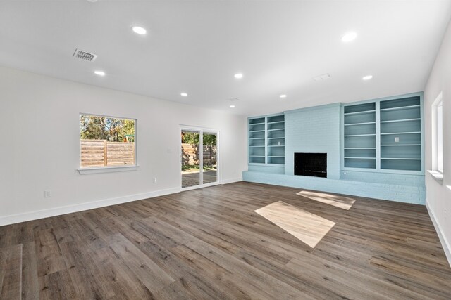 1520 Weyford Dr, Austin, TX 78757 - unfurnished living room with recessed lighting, a large fireplace, wood finished floors, and built in shelves
