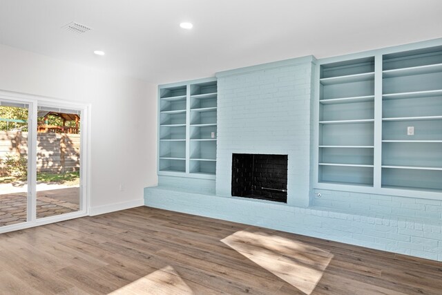1520 Weyford Dr, Austin, TX 78757 - unfurnished living room with wood finished floors, a fireplace, built in features, and recessed lighting