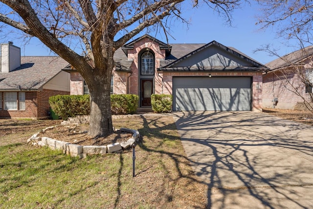 view of front facade with brick siding, a chimney, a shingled roof, concrete driveway, and a garage