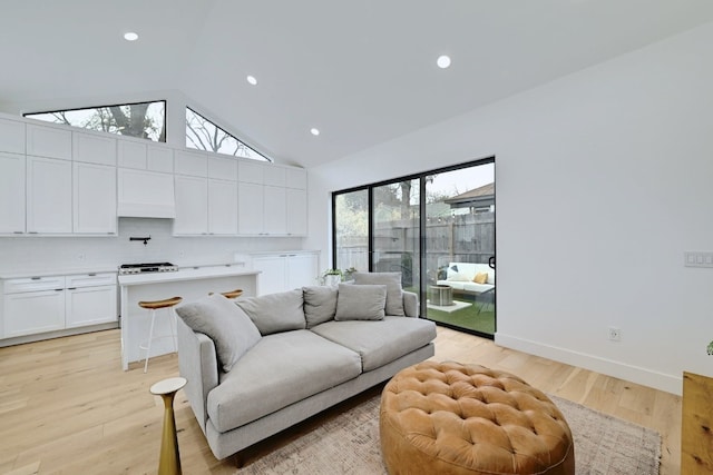 living room with light wood-style floors, baseboards, high vaulted ceiling, and recessed lighting