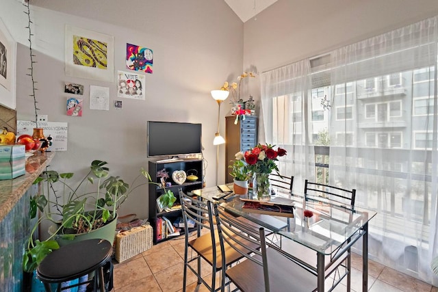 dining room with lofted ceiling and light tile patterned floors