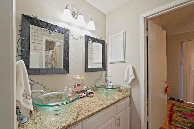2210 Pearl St Unit 305, Austin, TX 78705 - full bath with double vanity, a textured ceiling, and a textured wall