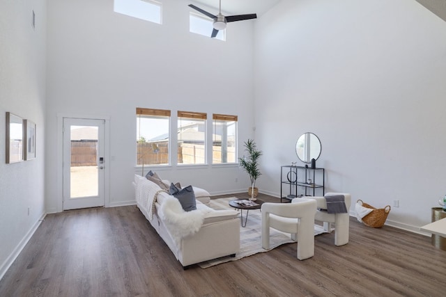 living area with a ceiling fan, baseboards, and wood finished floors