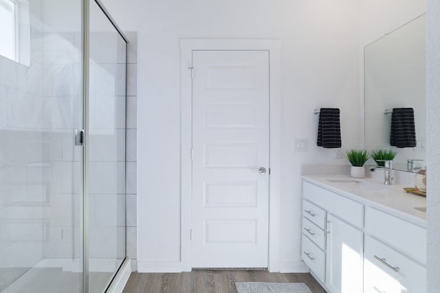 full bath featuring a shower stall, wood finished floors, and vanity