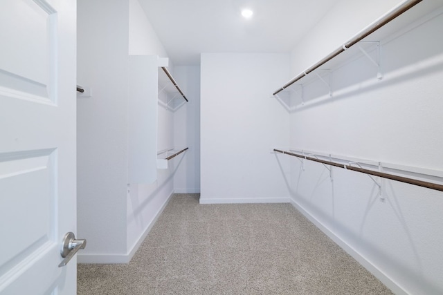 walk in closet featuring light carpet