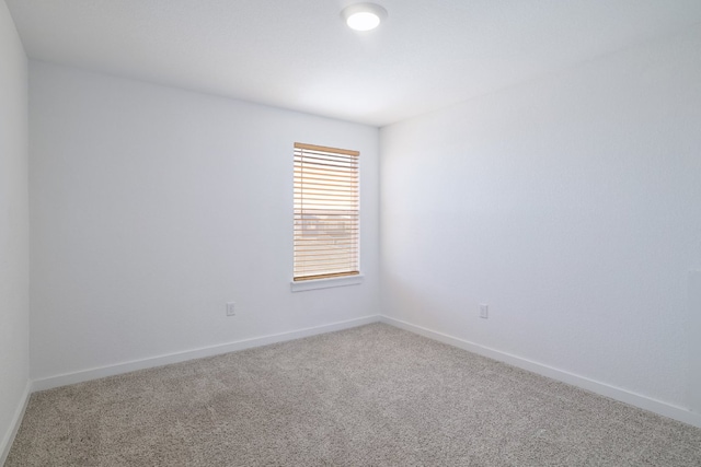 carpeted spare room with baseboards