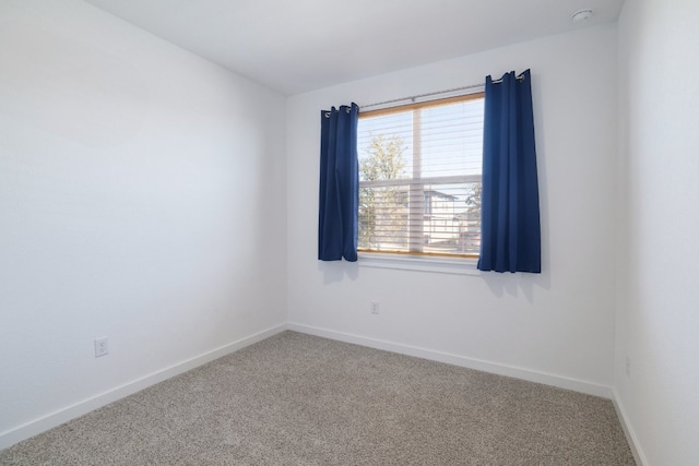 carpeted spare room with baseboards