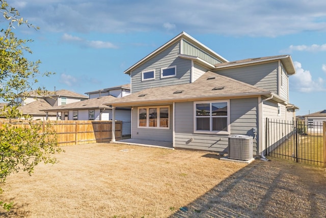 back of house with a fenced backyard, a lawn, and central air condition unit