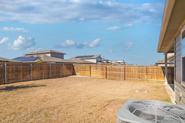 view of yard with central air condition unit and a fenced backyard