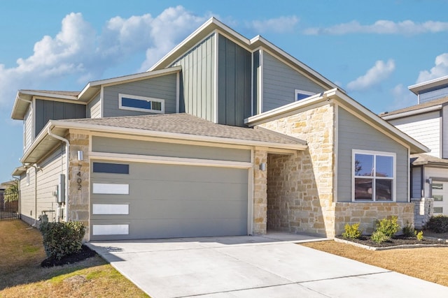 view of front of home with a garage, stone siding, board and batten siding, and concrete driveway