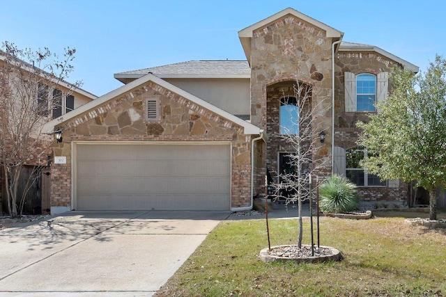 view of front of home featuring a front yard, stone siding, an attached garage, and concrete driveway