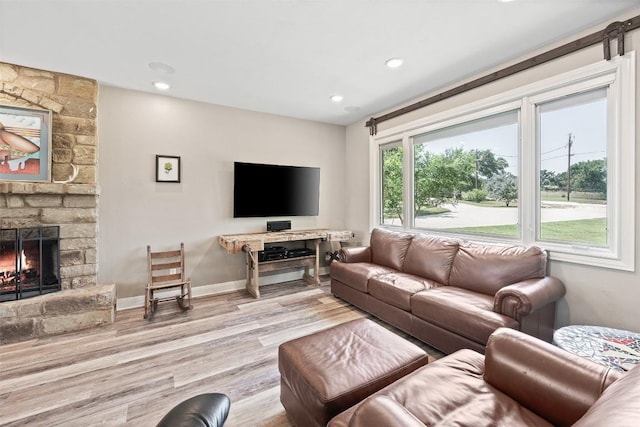 living area featuring a fireplace, baseboards, wood finished floors, and recessed lighting