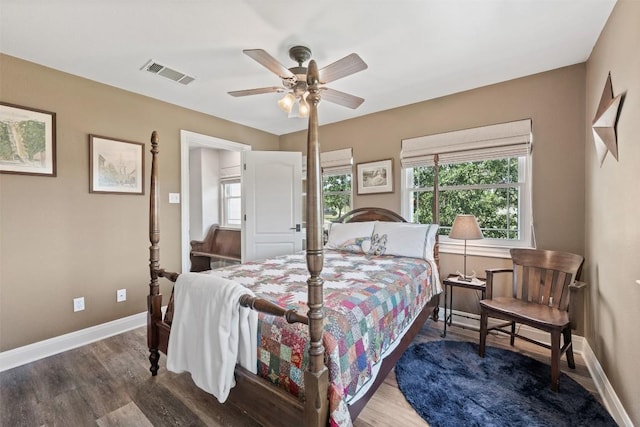 bedroom featuring baseboards, visible vents, ceiling fan, and wood finished floors