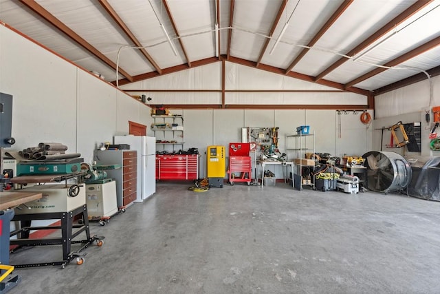 garage with metal wall, a workshop area, and freestanding refrigerator