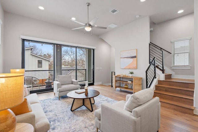 living area with recessed lighting, visible vents, stairway, wood finished floors, and baseboards