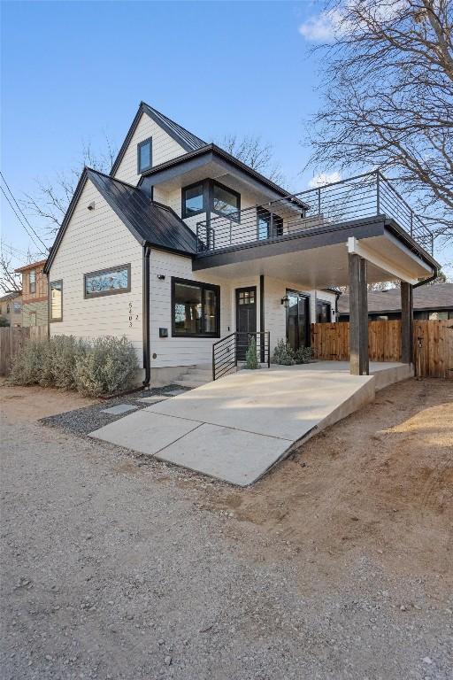 back of property with driveway, fence, and an attached carport