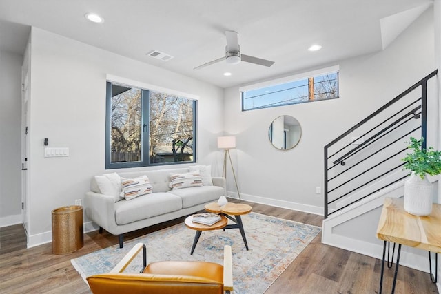 living room with recessed lighting, wood finished floors, visible vents, and stairs