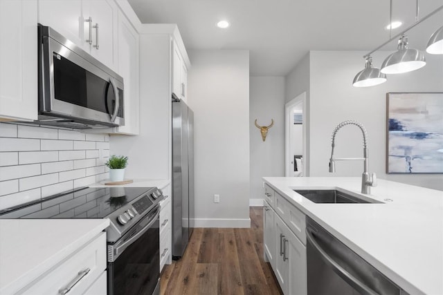 kitchen featuring stainless steel appliances, light countertops, a sink, and tasteful backsplash