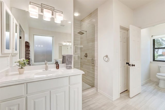 full bath with toilet, a shower stall, baseboards, and vanity