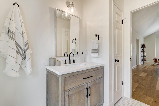 bathroom with vanity, baseboards, and wood finished floors