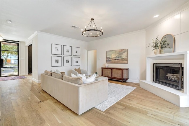 living room with light wood-type flooring, visible vents, a fireplace with raised hearth, and crown molding