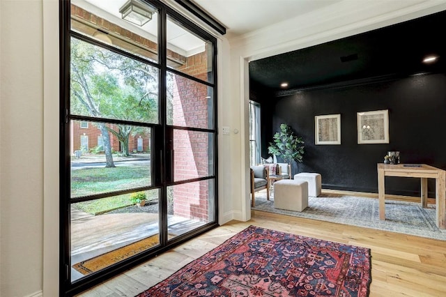 doorway featuring hardwood / wood-style floors and crown molding